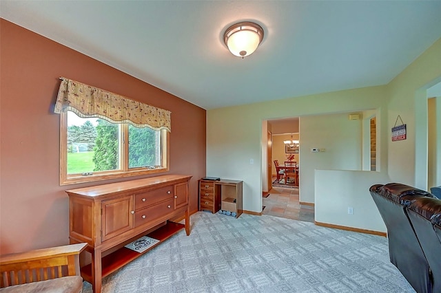 sitting room featuring light carpet and an inviting chandelier