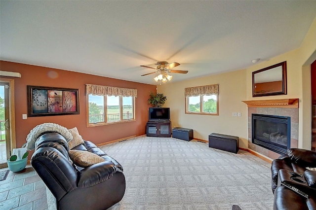 living room with ceiling fan and a fireplace