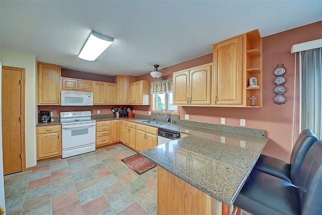 kitchen featuring sink, a breakfast bar area, kitchen peninsula, stone counters, and white appliances