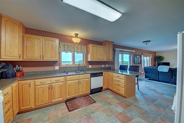 kitchen featuring dishwasher, sink, a healthy amount of sunlight, and kitchen peninsula