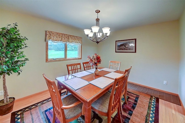 dining room featuring hardwood / wood-style flooring and an inviting chandelier