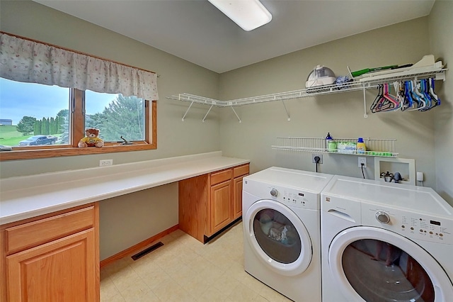 laundry room with independent washer and dryer and cabinets