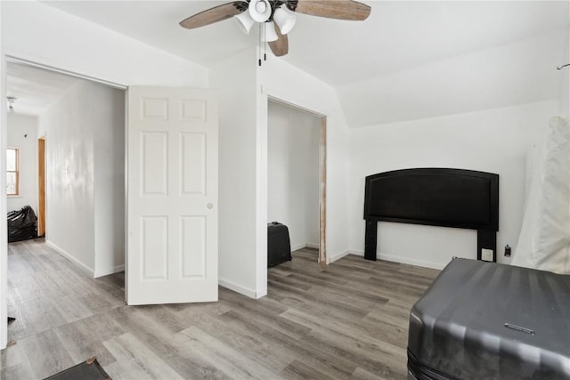 living area with light wood-type flooring, ceiling fan, and lofted ceiling