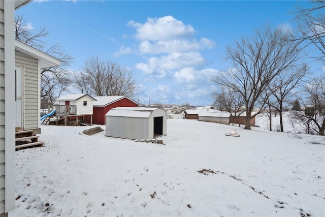 yard covered in snow featuring a storage unit