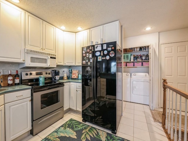 kitchen featuring black fridge with ice dispenser, white microwave, stainless steel electric range oven, separate washer and dryer, and light tile patterned flooring