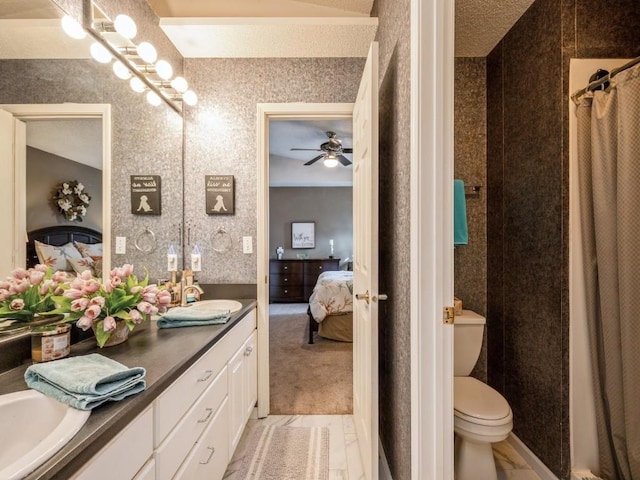 ensuite bathroom featuring wallpapered walls, vanity, toilet, and ensuite bathroom