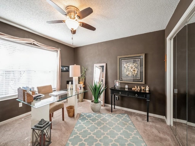 office area with a ceiling fan, carpet floors, a textured ceiling, and baseboards