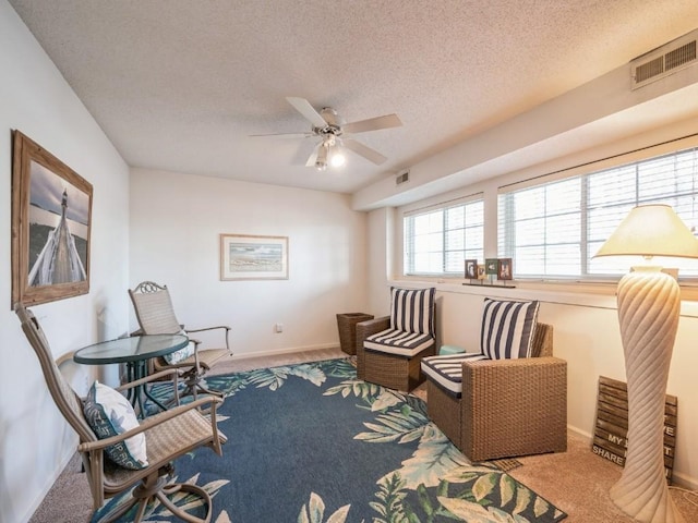 sitting room with baseboards, visible vents, a textured ceiling, and carpet flooring