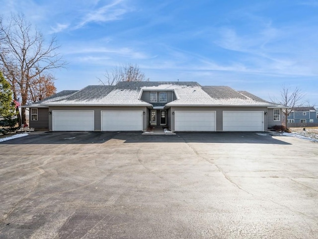 ranch-style house with roof with shingles, driveway, and an attached garage