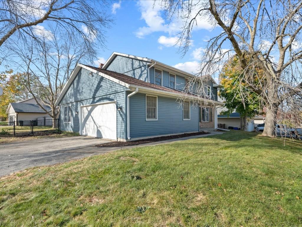 rear view of house with a lawn and a garage