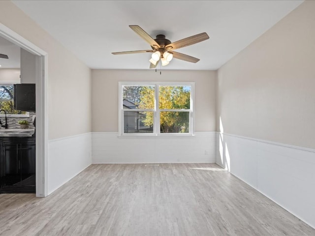 unfurnished room with ceiling fan, sink, and light hardwood / wood-style floors