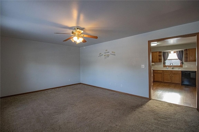 carpeted spare room featuring ceiling fan and sink