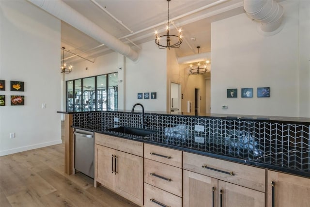 kitchen featuring a sink, a notable chandelier, dishwasher, and decorative light fixtures