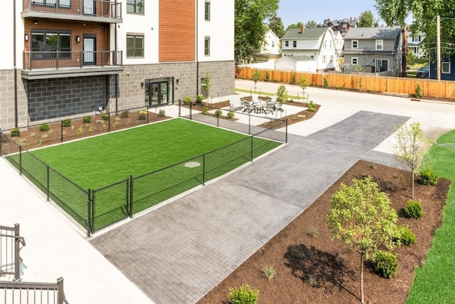 view of home's community featuring a patio, a lawn, fence, and a residential view