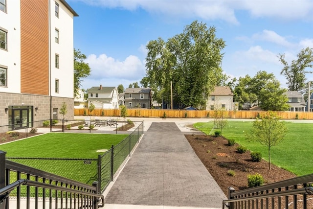 surrounding community with a lawn, fence, and a residential view