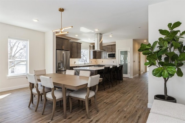 dining area with recessed lighting, dark wood finished floors, and baseboards