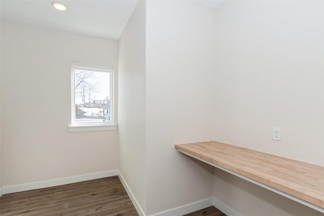 unfurnished office with dark wood-style floors, recessed lighting, built in study area, and baseboards