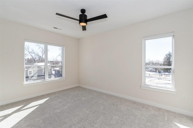 empty room featuring light carpet, baseboards, and visible vents