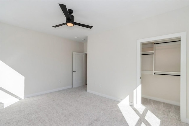 unfurnished bedroom with a closet, baseboards, a ceiling fan, and light colored carpet