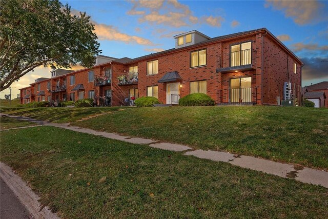 townhome / multi-family property featuring a lawn and cooling unit