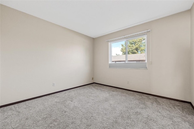 empty room featuring carpet flooring and baseboards