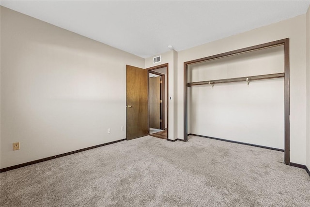 unfurnished bedroom with carpet floors, a closet, visible vents, and baseboards