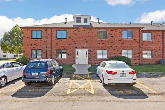 view of front of home featuring uncovered parking and brick siding