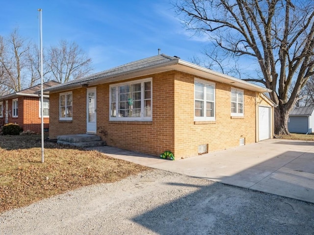 view of front of home featuring driveway, crawl space, and brick siding