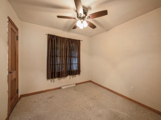 empty room with baseboards, baseboard heating, a ceiling fan, and light colored carpet