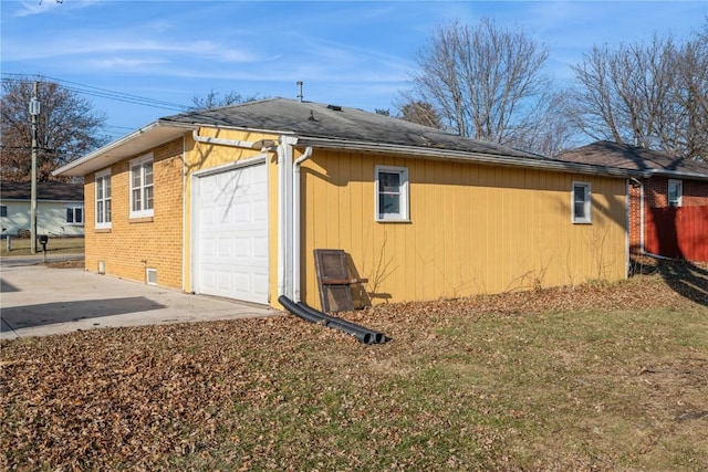 view of side of property featuring an outbuilding, brick siding, and driveway