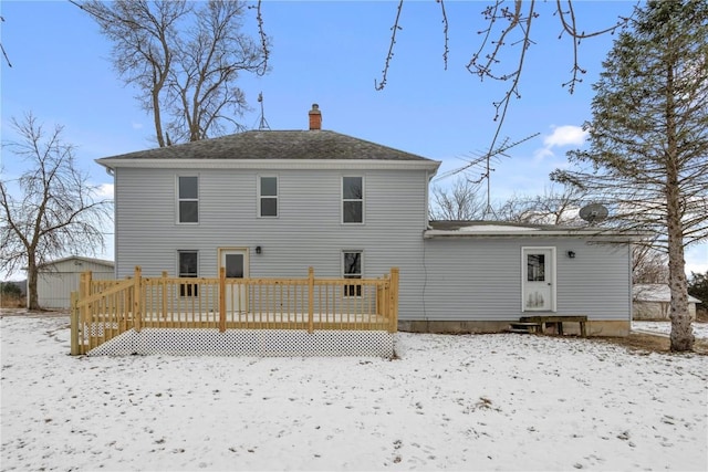 snow covered rear of property featuring a deck