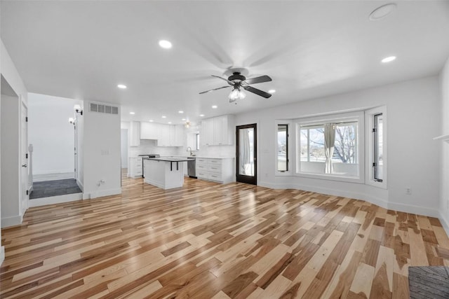 unfurnished living room with ceiling fan and light hardwood / wood-style floors