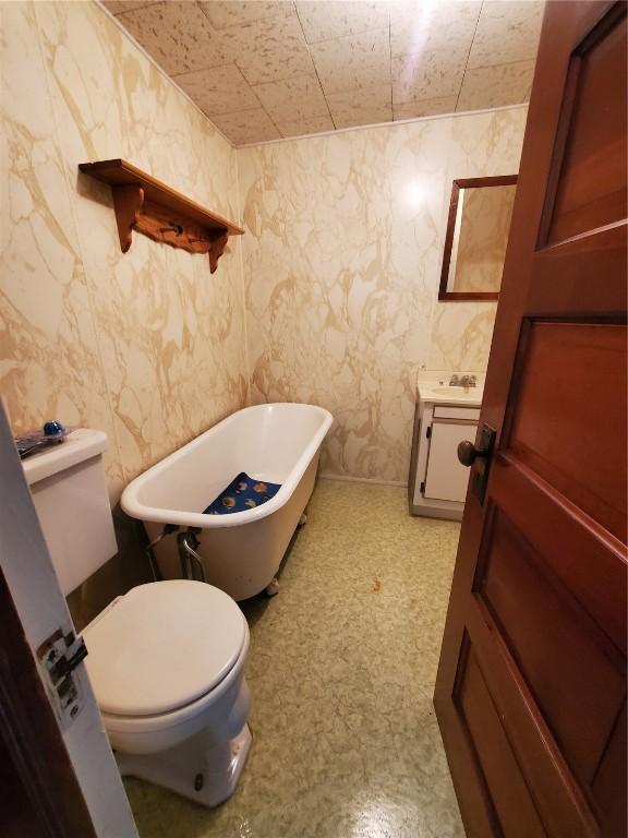 bathroom with a bathing tub, toilet, and sink