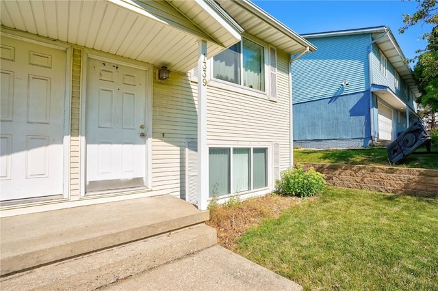 property entrance featuring a yard and a garage