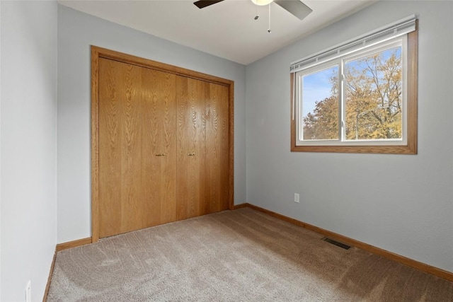 unfurnished bedroom with carpet flooring, a closet, and ceiling fan