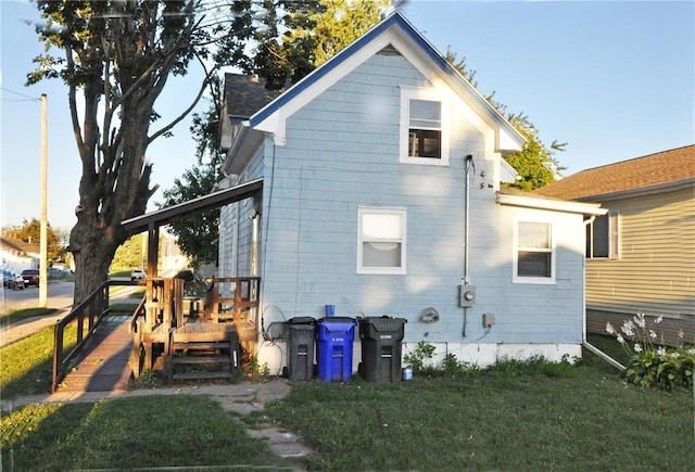 back of property with a lawn and a wooden deck