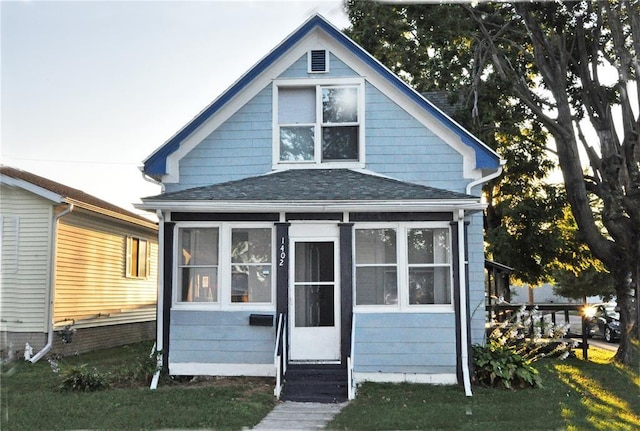 view of front facade with a sunroom and a front yard