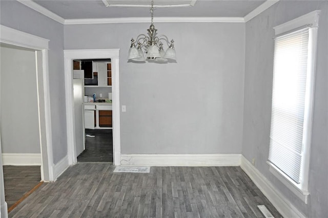 unfurnished dining area featuring dark hardwood / wood-style flooring, ornamental molding, and a chandelier