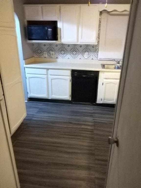 kitchen with white cabinetry, sink, tasteful backsplash, dark hardwood / wood-style flooring, and black appliances