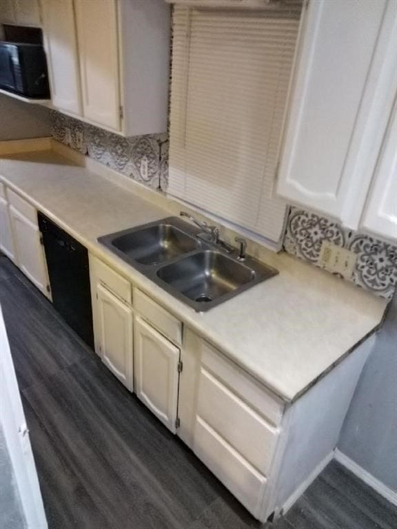 kitchen with dishwasher, sink, and dark wood-type flooring