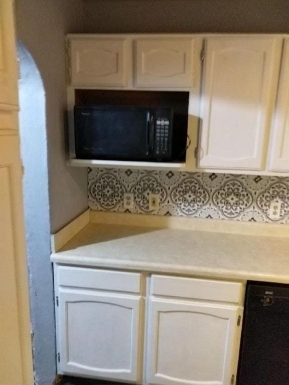 kitchen with black appliances and white cabinets