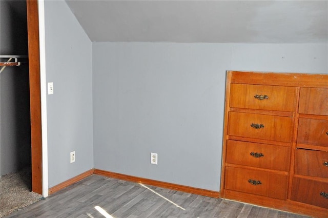 unfurnished bedroom featuring light wood-type flooring and vaulted ceiling