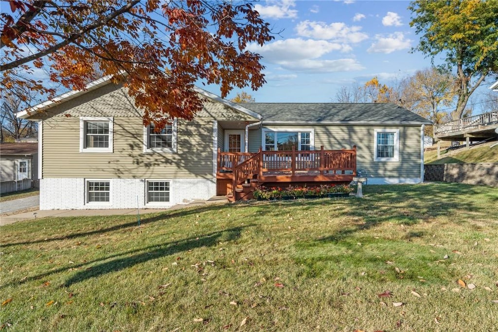 back of property featuring a lawn and a deck