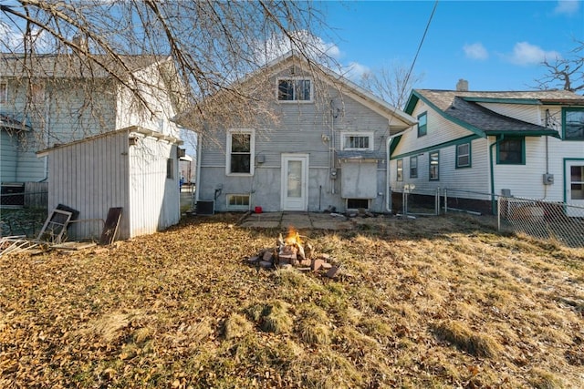 rear view of property featuring central AC unit and an outdoor fire pit