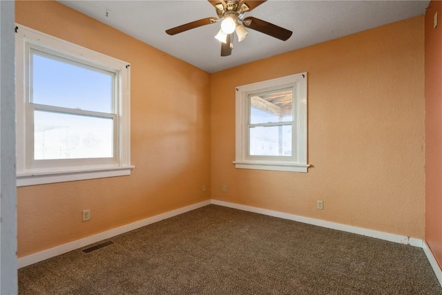 carpeted empty room featuring ceiling fan and plenty of natural light