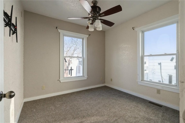 carpeted spare room featuring ceiling fan