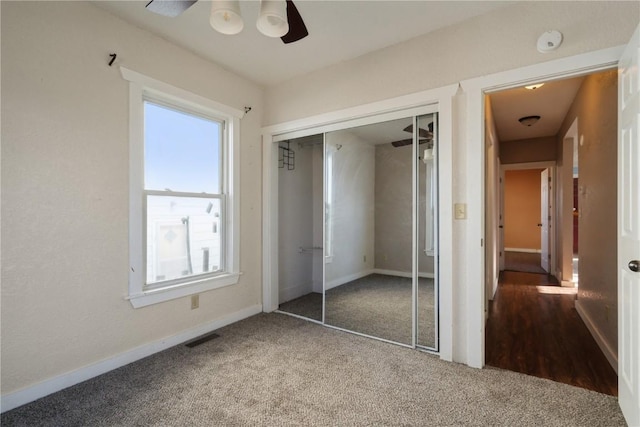 unfurnished bedroom featuring ceiling fan, carpet floors, and a closet