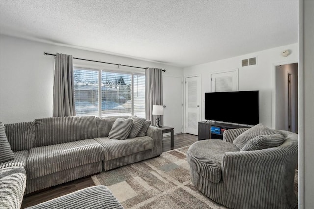 living room with dark hardwood / wood-style flooring and a textured ceiling