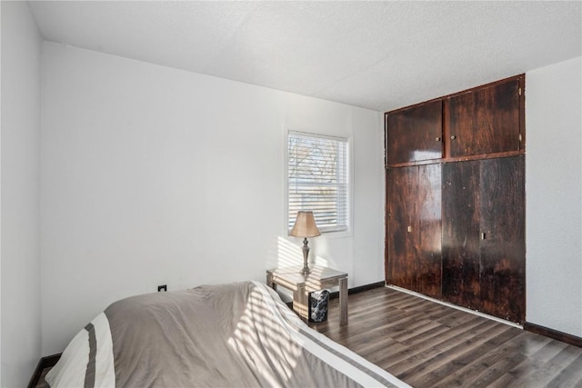 bedroom featuring a textured ceiling and dark hardwood / wood-style floors