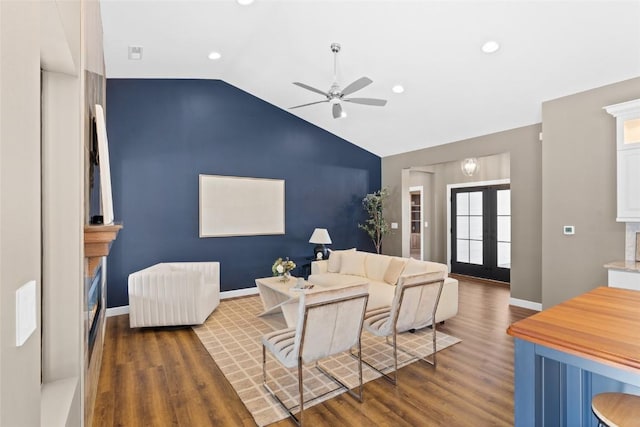 living room with ceiling fan, dark hardwood / wood-style flooring, lofted ceiling, and french doors